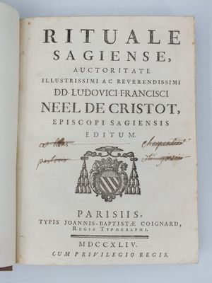 un livre ouvert sur lequel figure l'image d'un blason et un blason