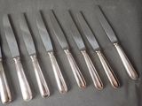 five knives and six knives on a table next to each other
