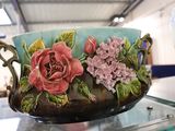 un vase orné de fleurs peintes, posé sur une table en verre