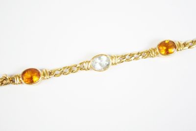 gros plan d'un bracelet en or avec des pierres multicolores