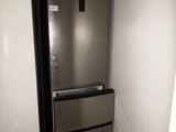 a refrigerator in the corner of a room with a door open
