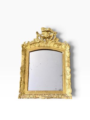 une image d'un miroir encadré d'or sur un mur blanc