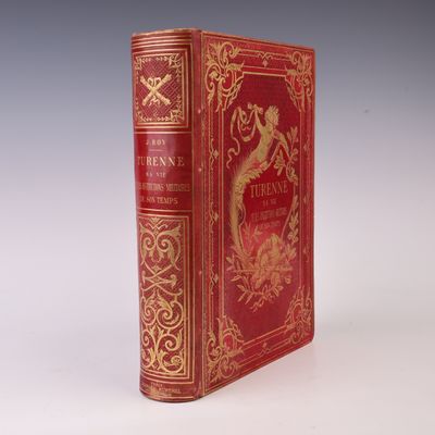 un vieux livre à la couverture rouge posé sur une table blanche
