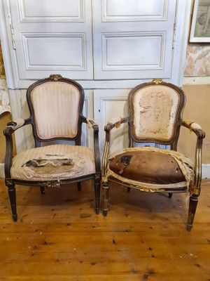 two chairs sitting next to each other on a wooden floor