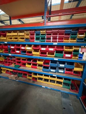 a large rack with many different colored bins in a warehouse