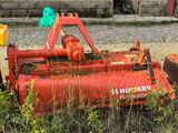 a red tractor that is sitting in the grass