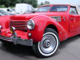 une voiture de collection rouge garée sur le bord de la route