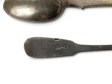 two spoons and a spoon rest on a white surface