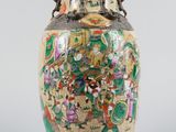 a vase with a painting on it sitting on a table