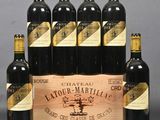 six bottles of red wine in a wooden crate on a table