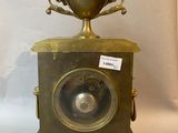 a small brass clock with a cup on top of it