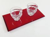 two glasses of water on a red tray on a white table