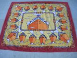 an image of a red and yellow rug with a picture of a man on a horse