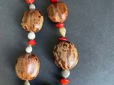 a necklace made of wood beads with red and white beads on it