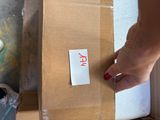 a person that is putting a piece of paper on a box