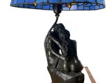 a lamp that is sitting on a table with a dragonfly shade on it