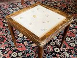 a small table with a small square top on a rug