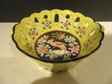 a yellow bowl with a bird on it on a table