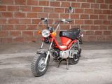 a red motorcycle that is parked in front of a brick wall