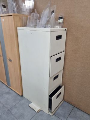 un réfrigérateur blanc posé à côté d'une commode à tiroirs