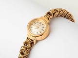 une image d'un gros plan d'une montre-bracelet sur une surface blanche
