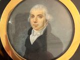 portrait d'un homme vêtu d'un manteau noir, avec un collier doré autour du cou