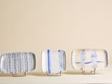trois petites assiettes ornées de motifs bleus et blancs, posées sur une table
