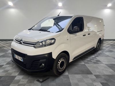 une camionnette blanche garée dans une pièce au sol en damier