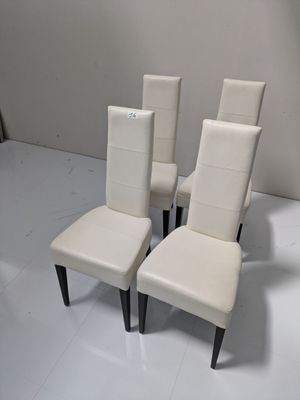trois fauteuils en cuir blanc aux pieds noirs et un mur blanc
