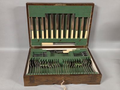 a wooden case with silverware in it on a white surface