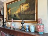 a painting on the wall above a fireplace with vases on it
