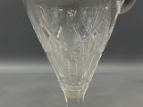 a clear glass pitcher with a handle on a table