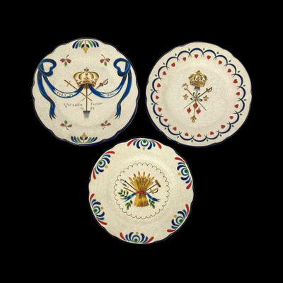 trois assiettes ornées de motifs, posées sur une surface noire