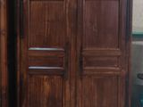 une armoire en bois à côté d'une table et d'une chaise dans une pièce