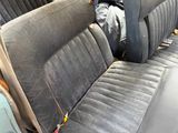 a black seat in the back of a car that is dirty