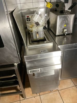 stainless steel counter top in a commercial kitchen with a fryer and sink