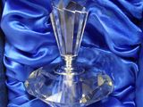 a glass candle holder in a blue box on a blue cloth