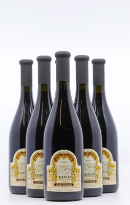 quatre bouteilles de vin sont alignées sur une surface blanche