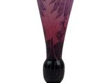 a purple glass vase with a black base on a white background