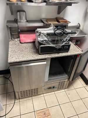 une petite cuisine avec une cuisinière et un micro-ondes posés sur le plan de travail