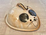 a cat shaped dish on a table with a cat ' s face painted on it