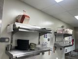 une cuisine avec de nombreuses étagères et de la vaisselle posée sur le plan de travail