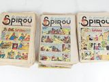 three old comic books sitting on top of each other on a table