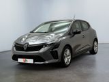 Une voiture grise est garée dans une pièce aux murs blancs.