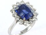 a close up of a blue sapphire and diamond ring on a white background