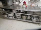 many pots and pans sitting on a stainless steel shelf