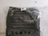 un sac en tissu noir posé sur une surface blanche