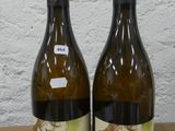 deux bouteilles de vin posées sur une table l'une à côté de l'autre