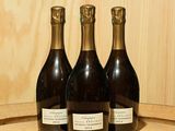 trois bouteilles de vin posées sur un tonneau en bois