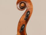 an antique violin with a scroll and a bow on a stand
